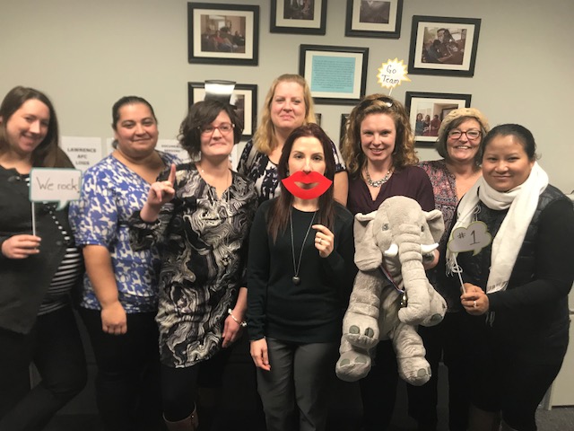 Seniorlink employees smiling at the office with photo props 